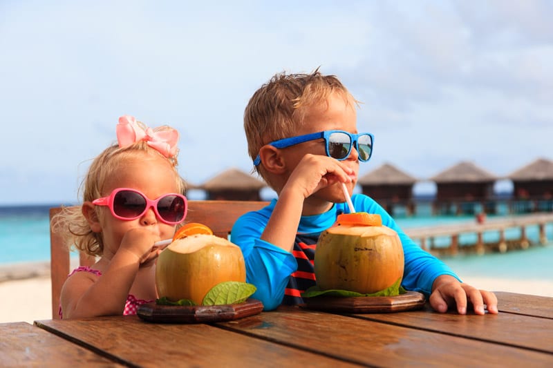 Little boys drinking coconut cocktail in a Maldivian resort