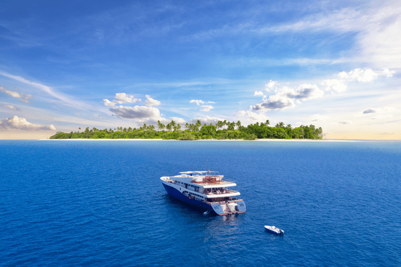 Luxury yacht in Maldives with tropical island in the background