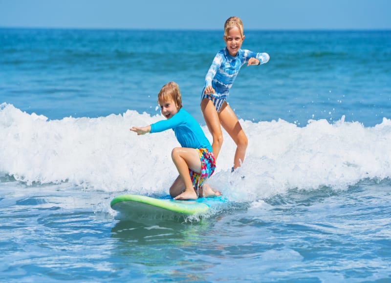 Children surfing in the Maldives