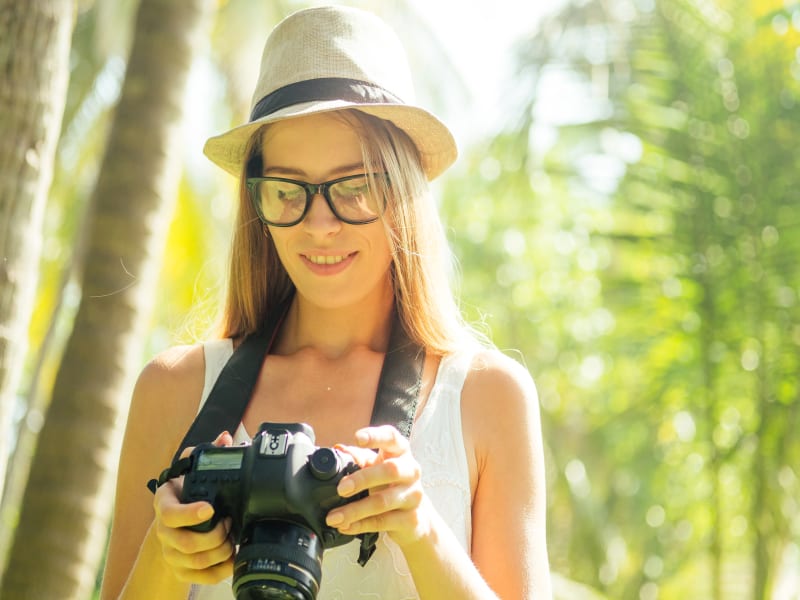 A traveler adjusts her camera settings while shooting in the Maldives