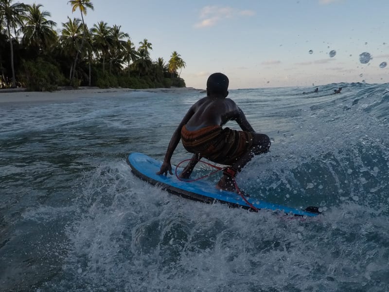 A kid enjoys a surf break in Fuvahmulah, Maldives