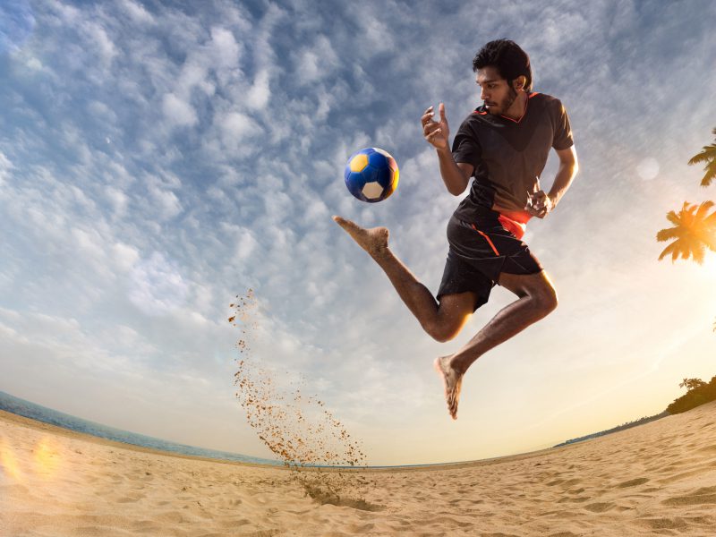 A young Maldivian plays football on the beach