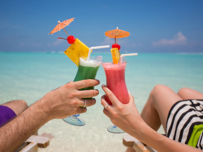 Couple drinking cocktails on Maldivian beach